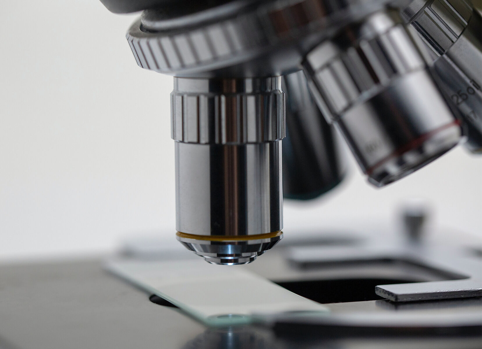 Close-up of a microscope lens looking at a slide.