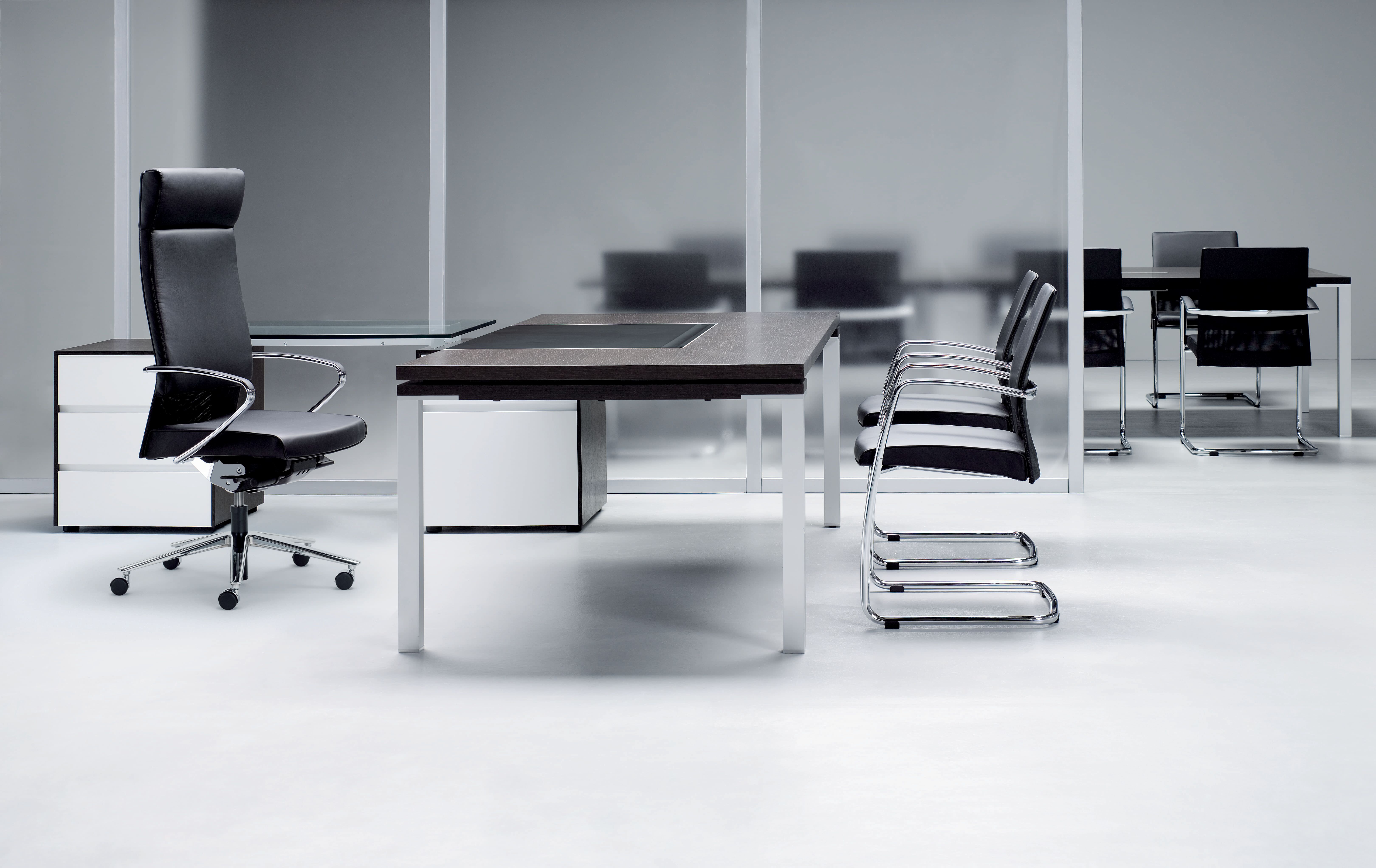Modern black and white office conference room with black office chairs and meeting desk.