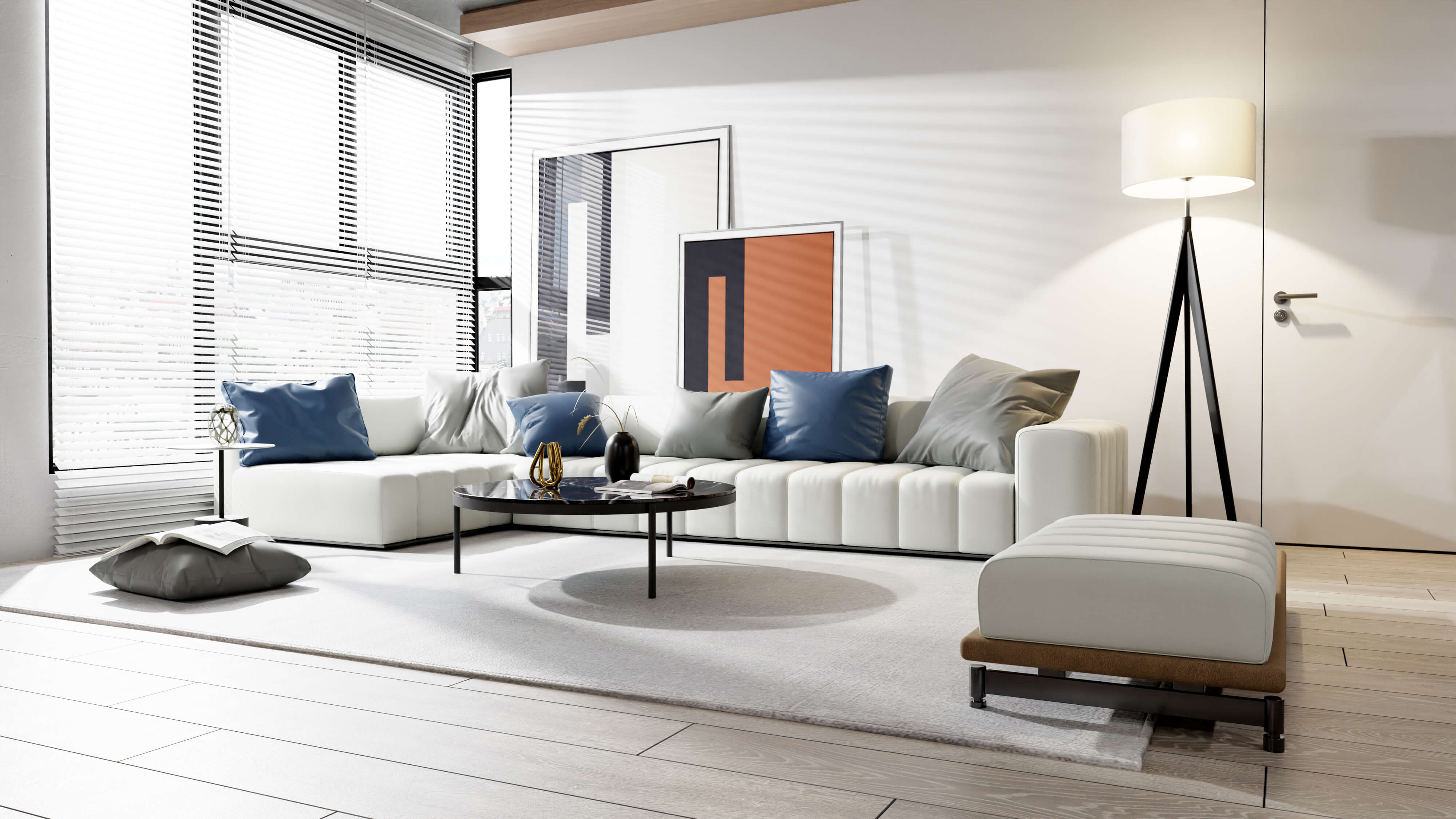White sectional couch with blue and gray pillows and white ottoman in modern light-filled living room with big windows.
